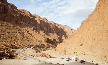 A road in the middle of a desert with mountains in the background