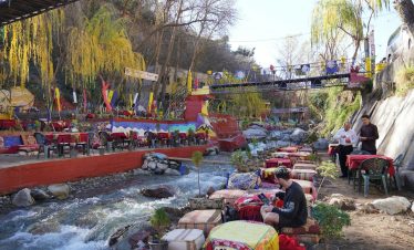 a group of people sitting at a table next to a river